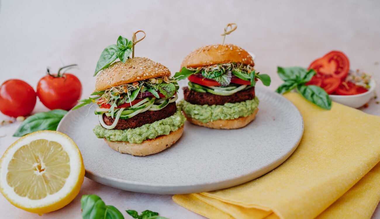 a plate of burgers with vegetables and herbs on it