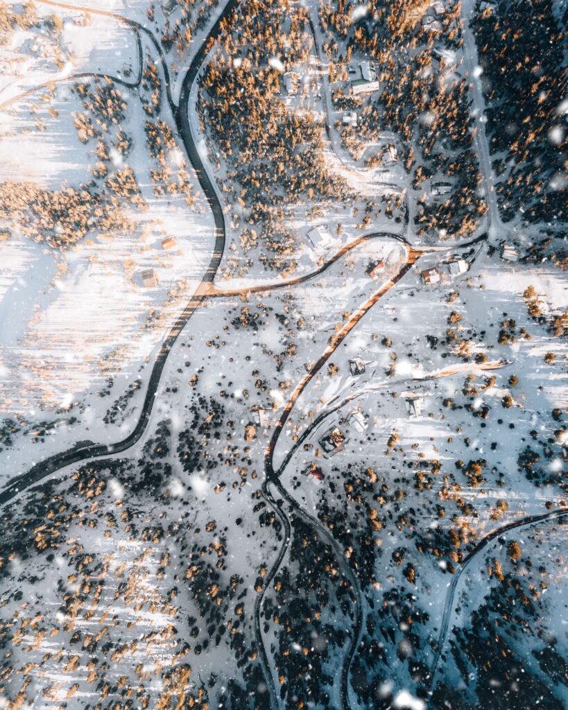 a snowy landscape with a river and houses