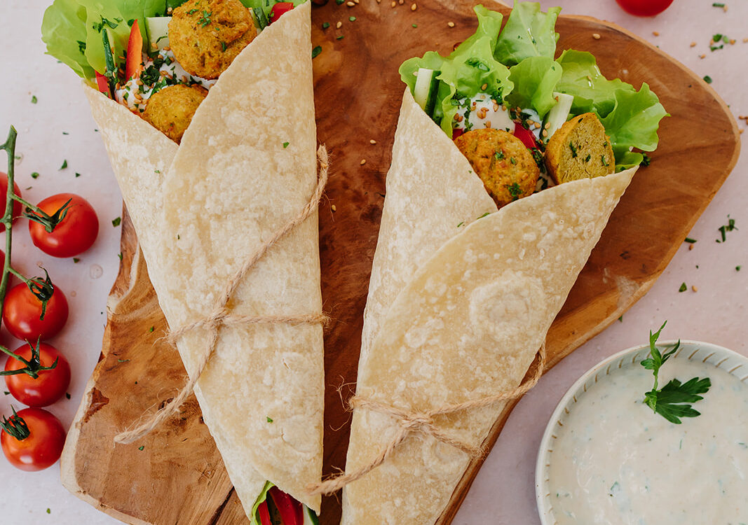 two tortillas wrapped on a table setting