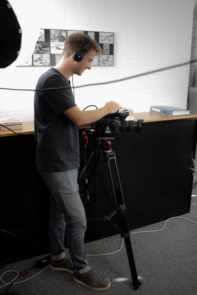 daniel wisuschil with headphones and a camera