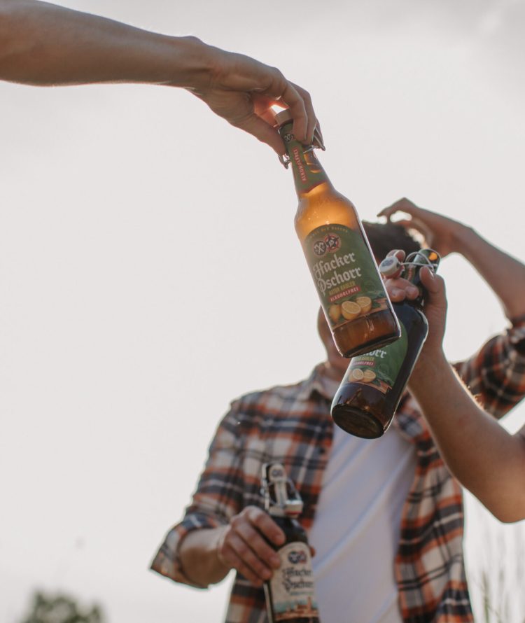 a group of people holding bottles of beer
